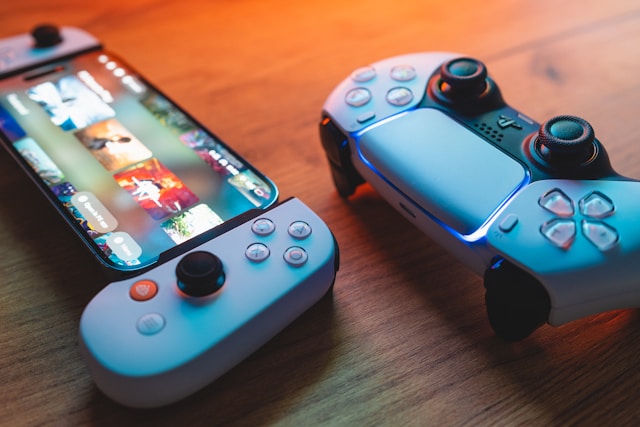New arrivals collection banner for refurbished electronics featuring a high-angle shot of a gaming console screen and a white gaming controller on a wooden tabletop surface.