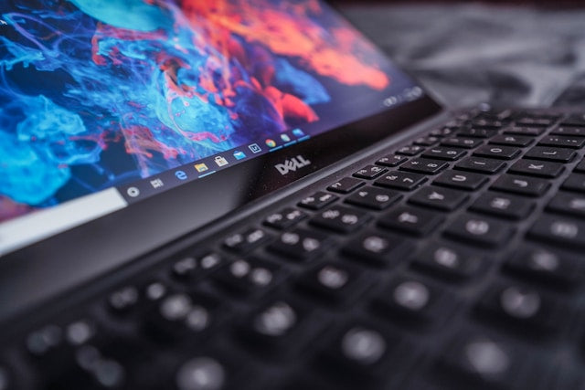Refurbished Dell laptops collection banner showing a close-up of an open Dell laptop with a colorful abstract blue and red wallpaper on the screen.