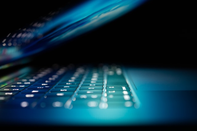 Refurbished laptops collection banner featuring a close-up of a sleek laptop with a vibrant blue backlit keyboard glowing in the dark.